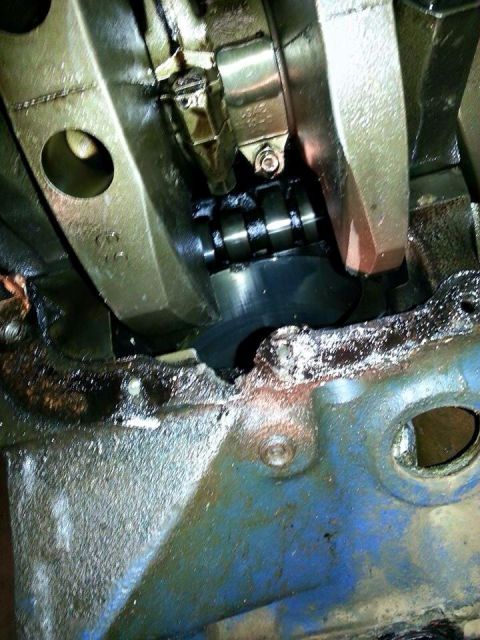 1979 Ford Bronco - Engine crankshaft and connecting rod assembly shown in detail, covered in oil.