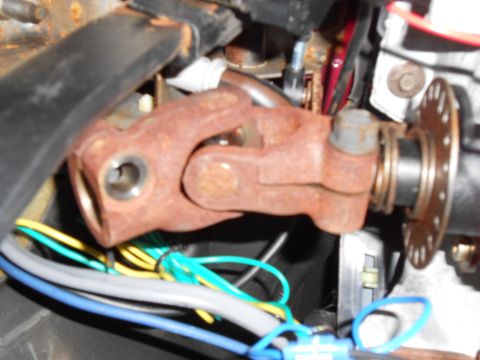 1992 Ford Bronco - Close-up of a rusty steering universal joint with visible wiring.