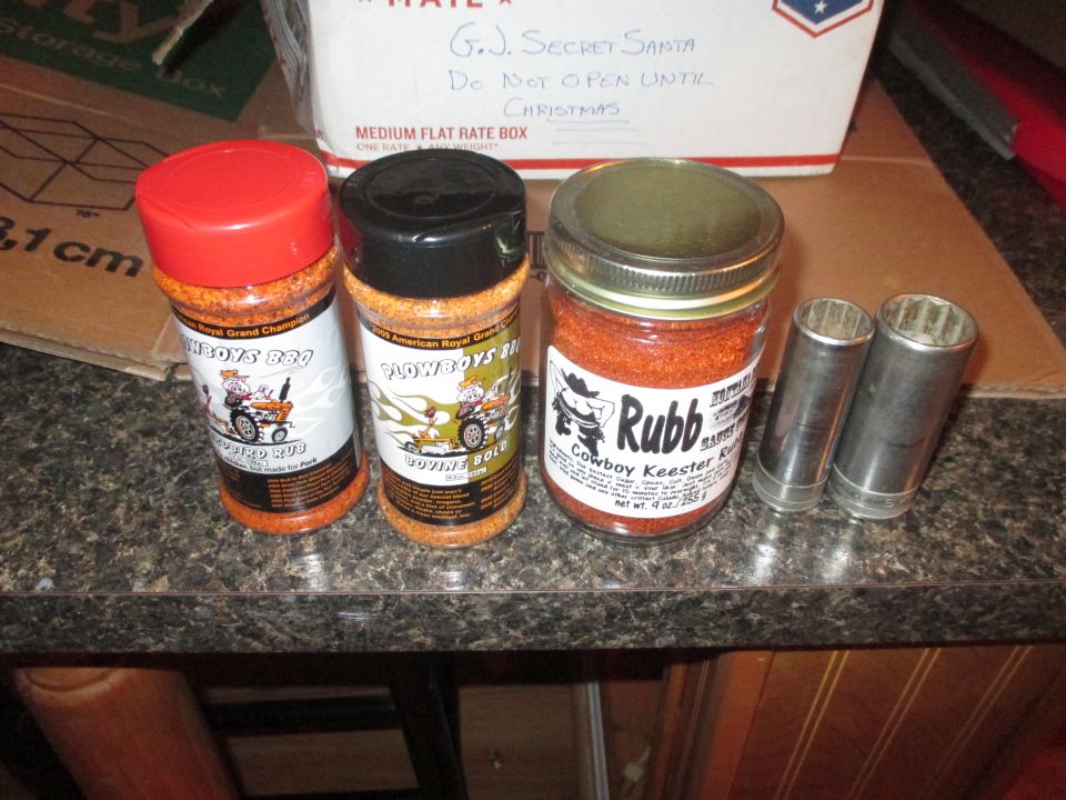 Three spice jars and two metal sockets on a speckled countertop