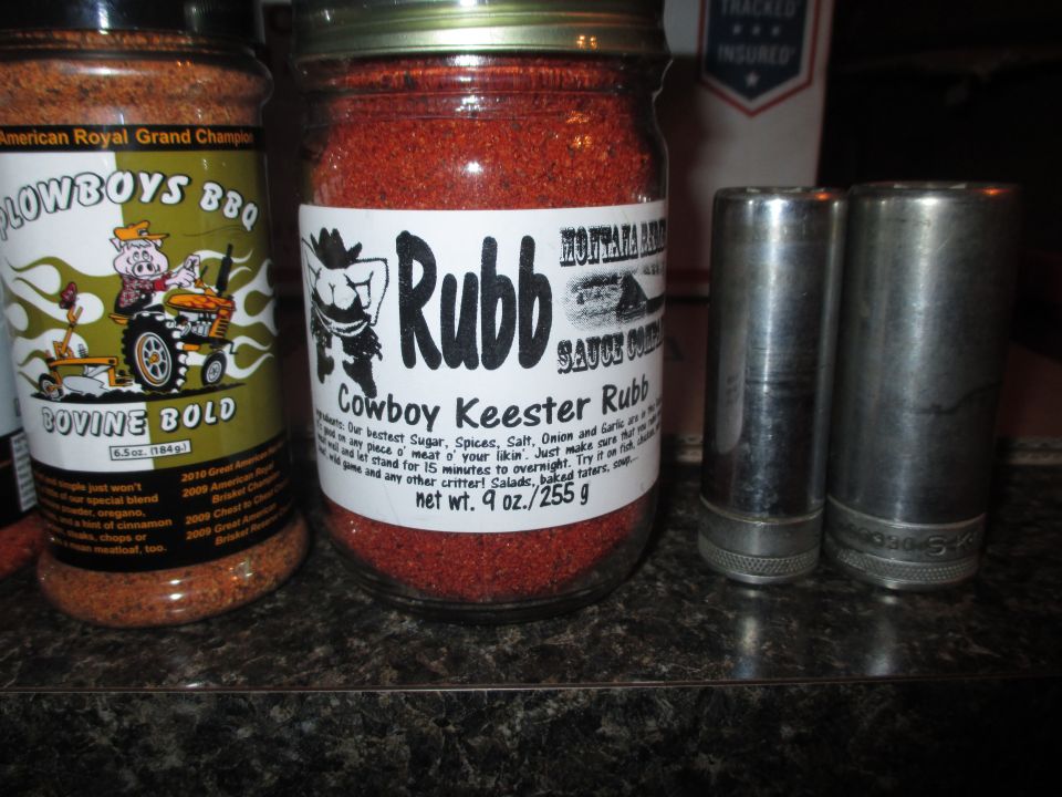 Two jars of spice rub and two metal sockets on a countertop
