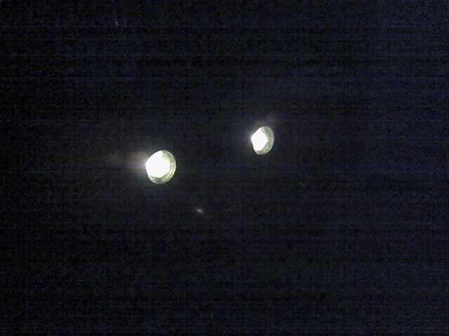 Two bright lights in a dark, grainy image.