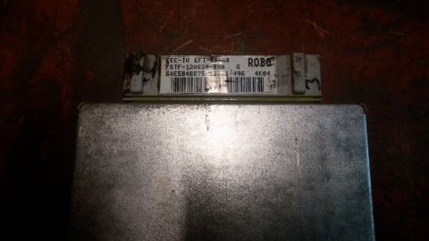 1995 Ford Bronco - A silver-colored automotive computer module with a label showing text and a barcode. The label reads "EEC-IV EFI-EB46B F5TF-12A650-BXA G 64…