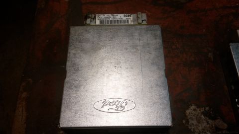 1995 Ford Bronco - A silver Ford ECU (Engine Control Unit) with the Ford logo embossed on the lid is shown. A label on the top of the unit displays text and a…