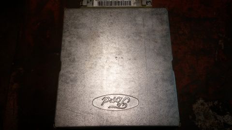 1995 Ford Bronco - A silver Ford ECU (Engine Control Unit) with the Ford logo embossed on top is shown in a close-up, overhead view. A label with a barcode an…