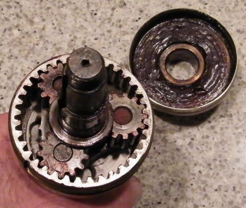 1909 Ford Model T - A close-up view shows a disassembled planetary gear set with grease applied to the lid. The gears and central shaft are visible within the…