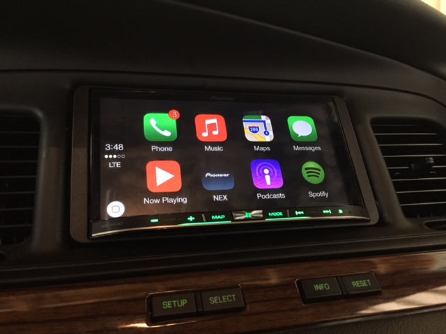 Pioneer NEX touchscreen showing Apple CarPlay home screen in a car dashboard with wood trim