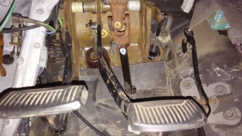 1995 Ford Bronco - The image shows the pedal assembly of a vehicle, including the brake and clutch pedals, steering column linkage, and various wires and spri…