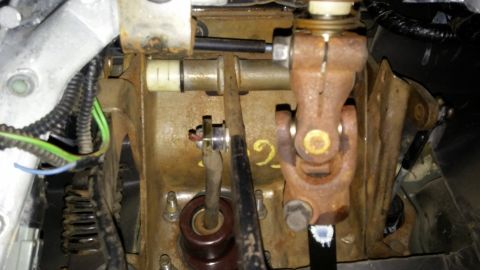 1995 Ford Bronco - This is a close-up view of the steering column components under the dashboard of a vehicle, showing rusty metal brackets, a universal joint…