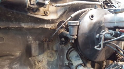 1995 Ford Bronco - This is a close-up view of the firewall area of a vehicle, showing the brake booster and master cylinder reservoir. The firewall appears to…