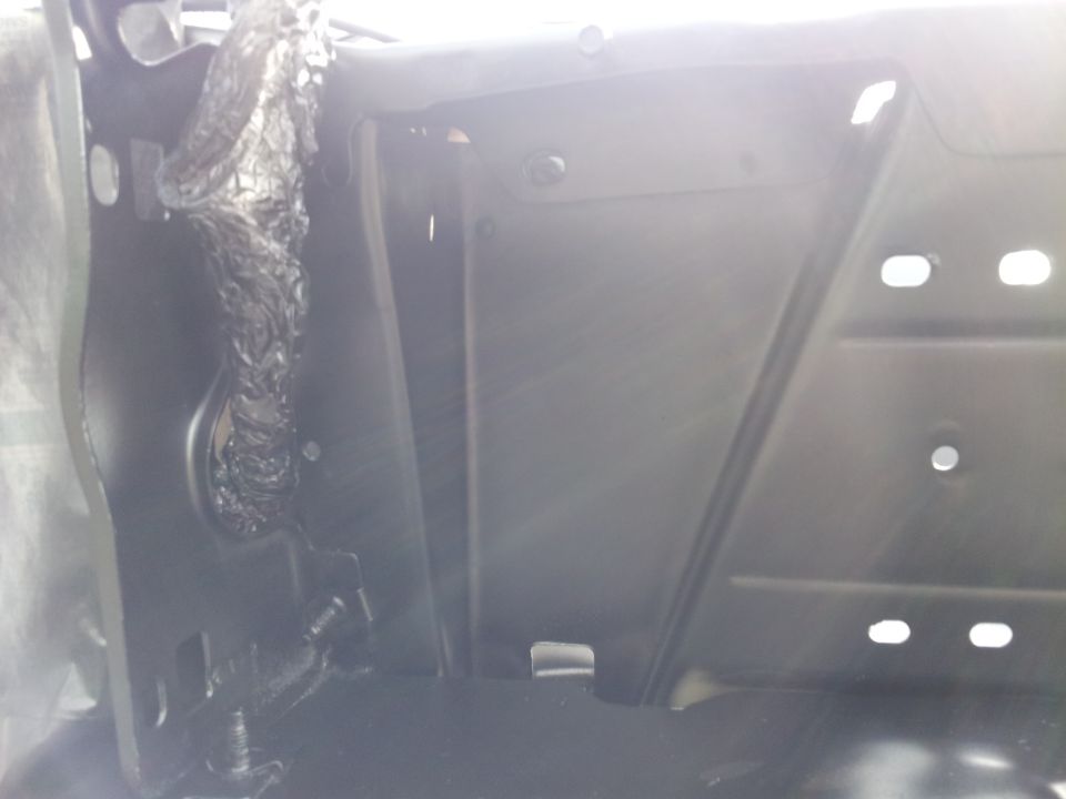Interior of a vehicle showing black metal panel with wiring.