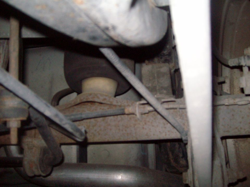 Underside of a vehicle showing suspension and exhaust components.