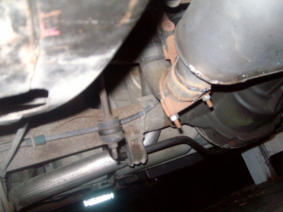 Underside of a vehicle showing exhaust system and suspension components.
