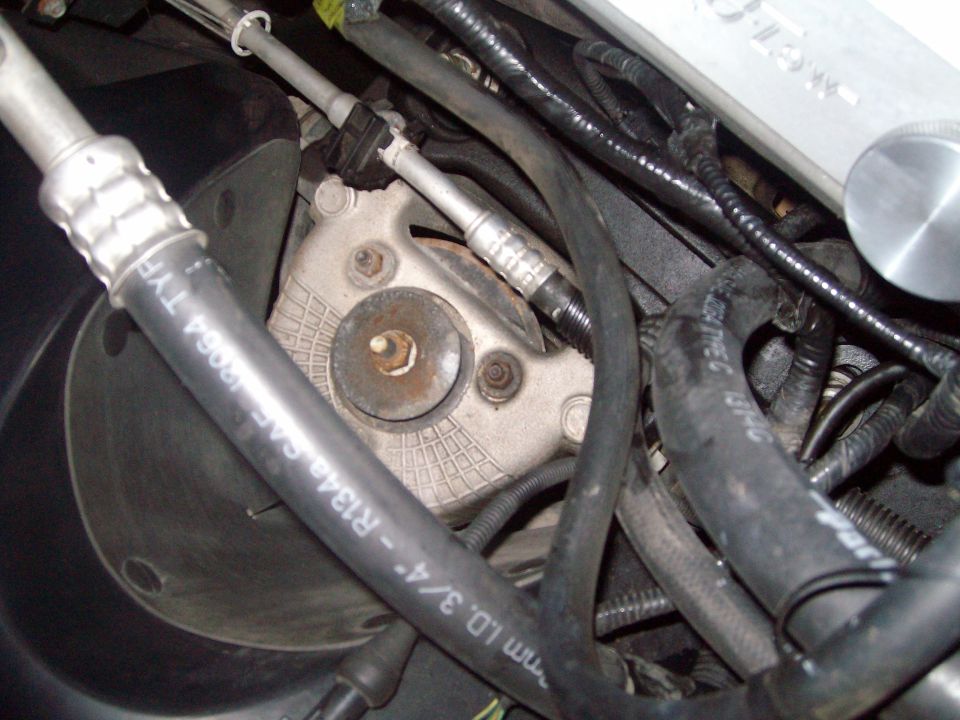 2004 Ford Crown Victoria engine bay with AC compressor mount and hoses.