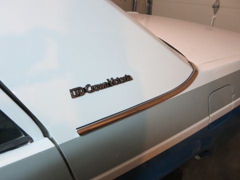 1991 Ford LTD Crown Victoria - Photograph of a Ford LTD Crown Victoria emblem on the front fender, not a technical document.