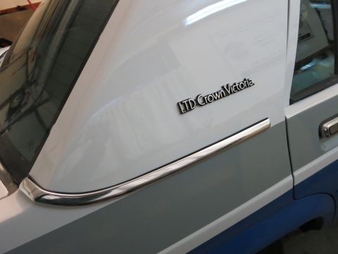 1991 Ford LTD Crown Victoria - Photograph of an LTD Crown Victoria emblem on a two-tone blue and silver body, not a technical document.