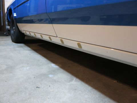 1991 Ford LTD Crown Victoria - Photograph of the rocker panel and trim along the lower body of a blue and tan car, not a technical document.
