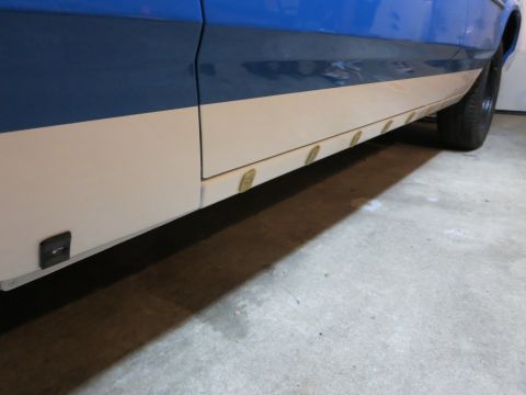 1991 Ford LTD Crown Victoria - Photograph of the lower body panel, rocker trim, and rear wheel of a two-tone car, not a technical document.