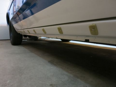 1991 Ford LTD Crown Victoria - Photograph of the rocker panel and trim clips on the lower body of a two-tone car, not a technical document.