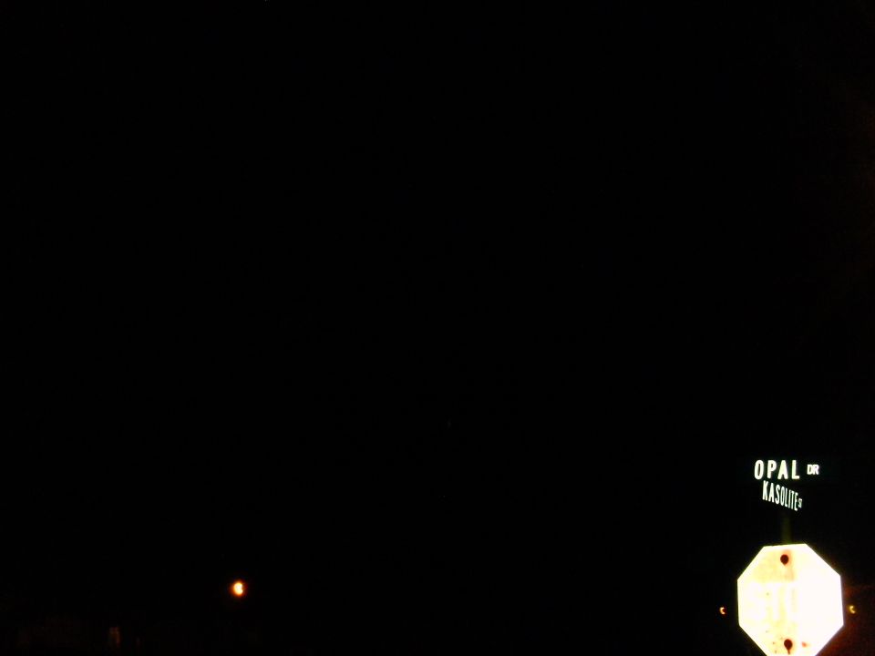 Street sign for Opal Dr Kasolite and a stop sign at night.
