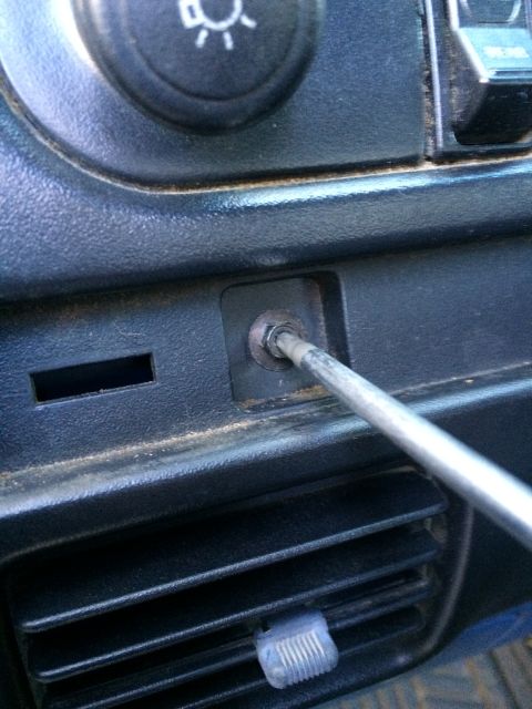 1990 Ford Bronco - A screwdriver is used to remove the headlight switch from the dashboard of a 1990 Ford Bronco.