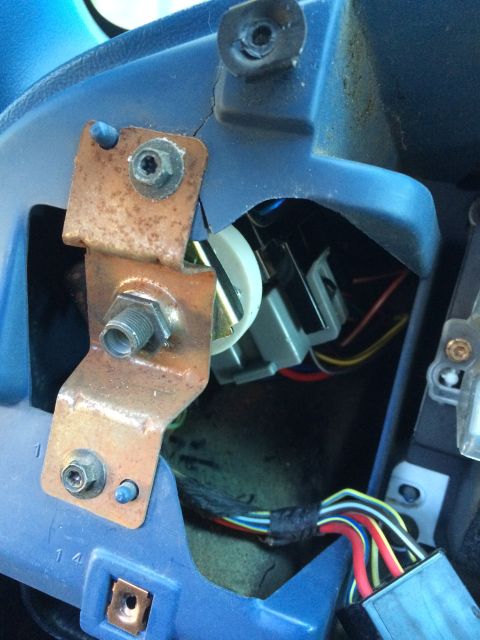 1990 Ford Bronco - Close-up of a vehicle's headlight switch assembly, showing wiring and mounting hardware.
