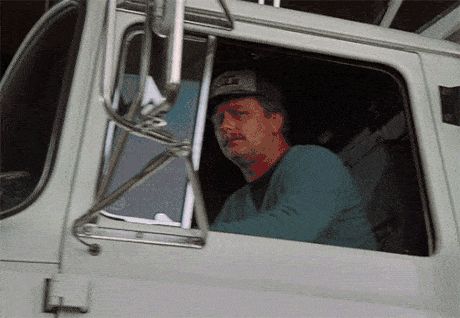 2000 Mercury Grand Marquis - A man is seen from the side, looking out the window of a white truck's cab.