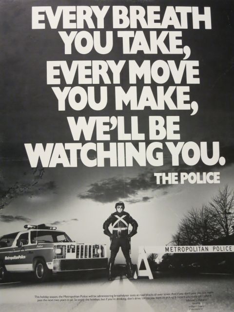 1991 Ford LTD Crown Victoria - Black-and-white Metropolitan Police breathalyzer campaign poster reading Every Breath You Take, Every Move You Make, We'll Be Watching You.