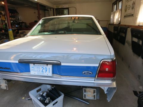 1991 Ford LTD Crown Victoria - This Ford Crown Victoria LTD police car is parked indoors, possibly in a garage, with its rear bumper removed.