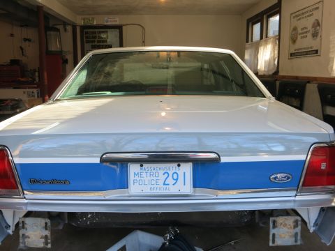 1991 Ford LTD Crown Victoria - This police car, identified as a LTD Crown Victoria, is shown from the rear, parked in a garage.