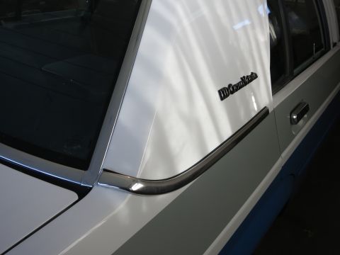 1991 Ford LTD Crown Victoria - Close-up of a white 1991 Ford Crown Victoria LTD's rear pillar, showing the 'Crown Victoria' badging.