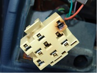 1990 Ford Bronco - Close-up of a damaged electrical connector, possibly related to a headlight switch, showing signs of burning.