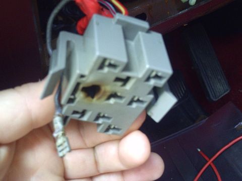 1990 Ford Bronco - A burned electrical connector is held in a hand, showing damage to the internal contacts.