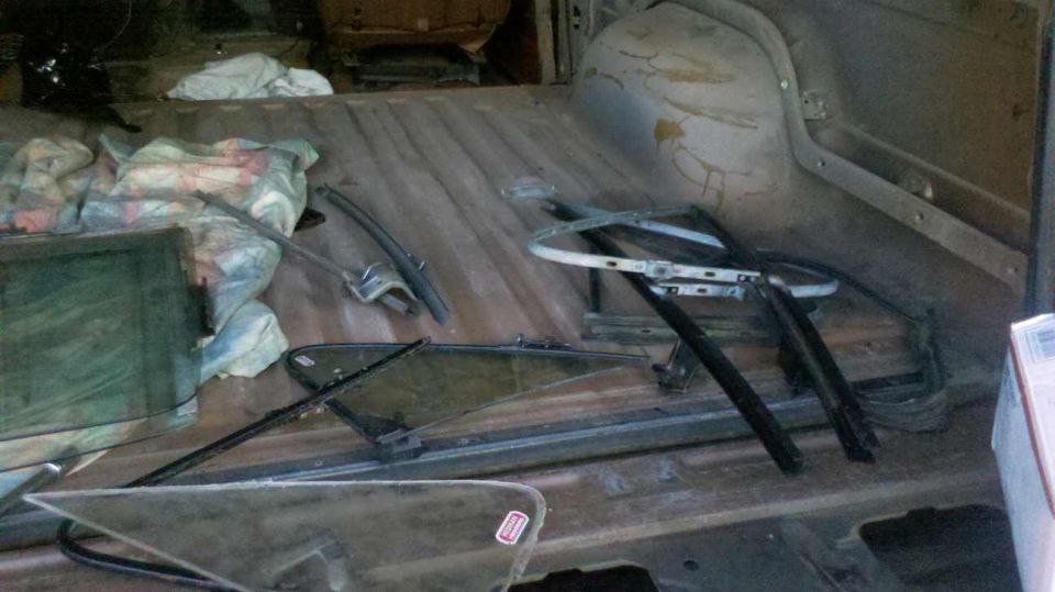 Inside of a vehicle with window parts and fabric bundles on the floor