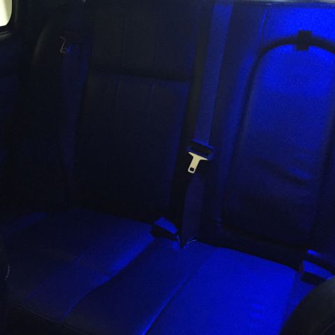 2007 Ford Crown Victoria - The rear seats of a vehicle are illuminated with blue accent lighting.