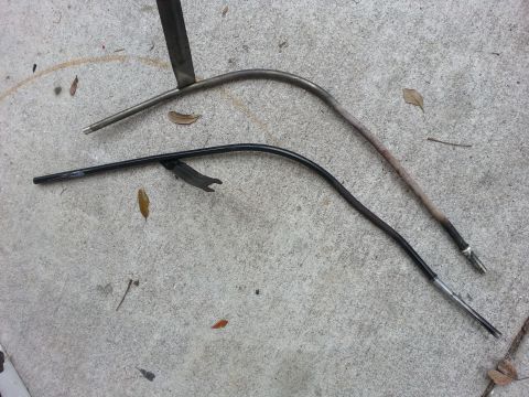 1995 Ford Bronco - Two metal tubes, likely automotive parts, are shown on a concrete surface with scattered leaves.