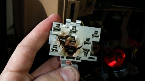 1991 Ford F-250 - A close-up view of a damaged electrical relay socket with visible signs of melting and burning.
