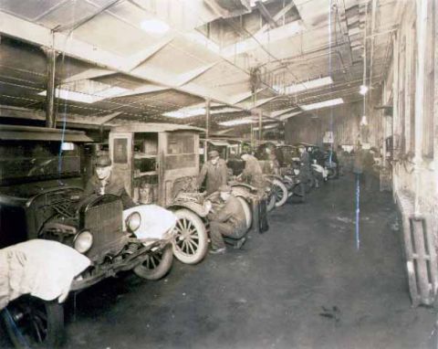 1909 Ford Model T - Workers assemble 1909 Ford Model T vehicles in a factory setting.