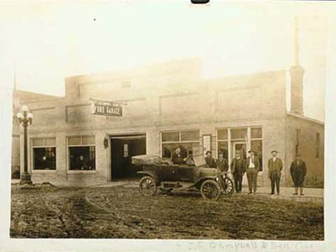 1909 Ford Model T - A group of men pose with a touring car in front of a Ford dealership.