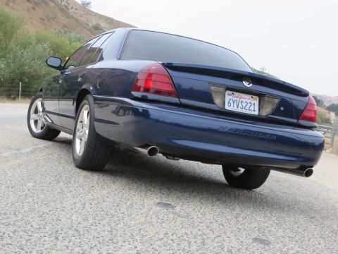 2003 Mercury Marauder - The rear of a dark blue sedan with a spoiler and dual exhaust pipes is visible.
