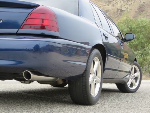 2003 Mercury Marauder - A dark blue sedan is parked on a paved surface with hills and trees in the background.