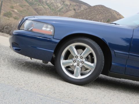 2003 Mercury Marauder - Front quarter view of a blue 2003 Mercury Marauder, highlighting its distinctive chrome wheels and body lines.