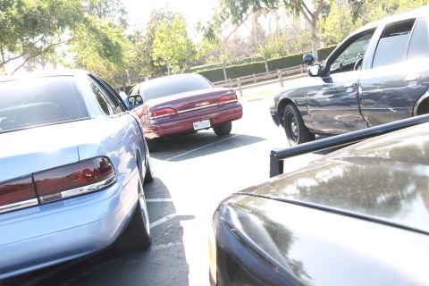 2004 Ford Crown Victoria - A 2004 Ford Crown Victoria is parked among other sedans in a sunny outdoor lot.