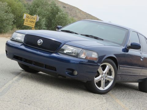 2003 Mercury Marauder - A blue 2003 Mercury Marauder is parked on a road with a speed limit sign visible.