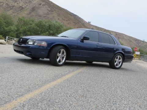 2003 Mercury Marauder - Side view of a dark blue 2003 Mercury Marauder parked on a road.