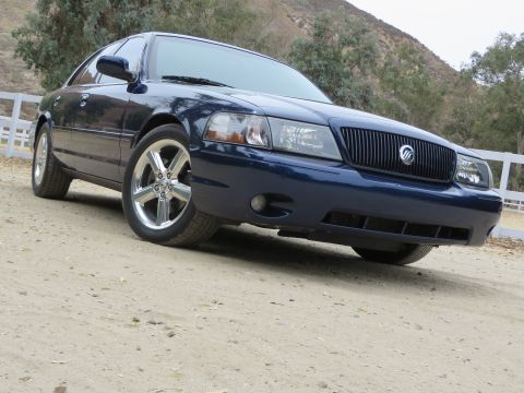 2003 Mercury Marauder - A dark blue 2003 Mercury Marauder is shown from a low 3/4 front angle, its distinctive grille and chrome wheels.