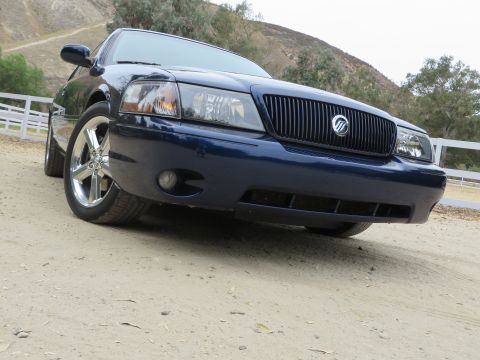 2003 Mercury Marauder - Front view of a dark blue 2003 Mercury Marauder parked on a dirt road with hills in the background.