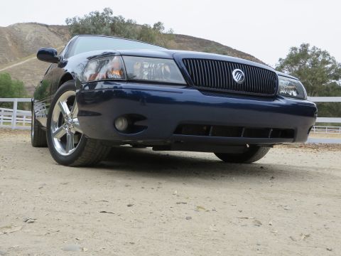 2003 Mercury Marauder - The front grille and badge of a dark blue sedan are visible in this low-angle shot.