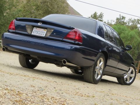 2003 Mercury Marauder - Rear view of a dark blue 2003 Mercury Marauder sedan parked on a dirt road.