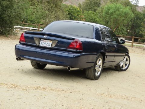 2003 Mercury Marauder - The rear of a dark blue 2003 Mercury Marauder is shown from a 3/4 angle, parked outdoors.