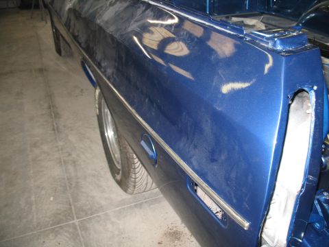 1972 Ford Ranchero - The rear quarter panel of a blue vehicle shows signs of bodywork and is missing its tail light assembly.